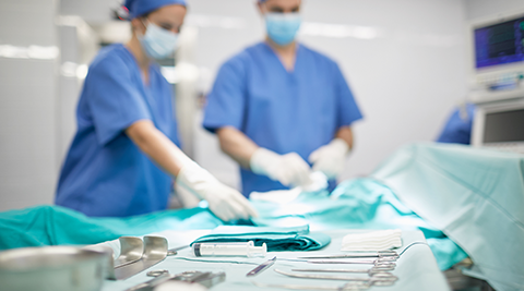 Nurses in scrubs with surgical tools